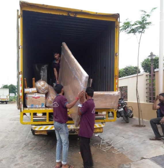 Team carefully wrapping furniture and packing household goods